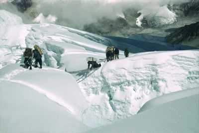 Sherpas in the icefall crossing a ladder bridge over a crevasse