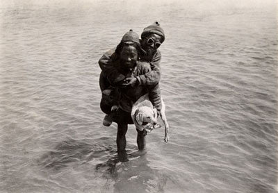 Porters fording a river carrying a dog