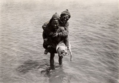 Porters fording a river carrying a dog
