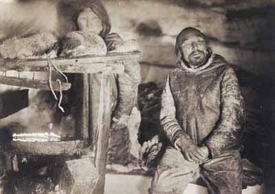 Man and his wife in snow hut, Northwest Territories