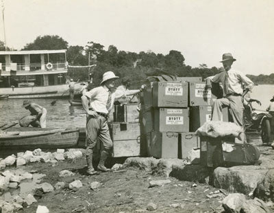 Expedition members with boxes on the river side